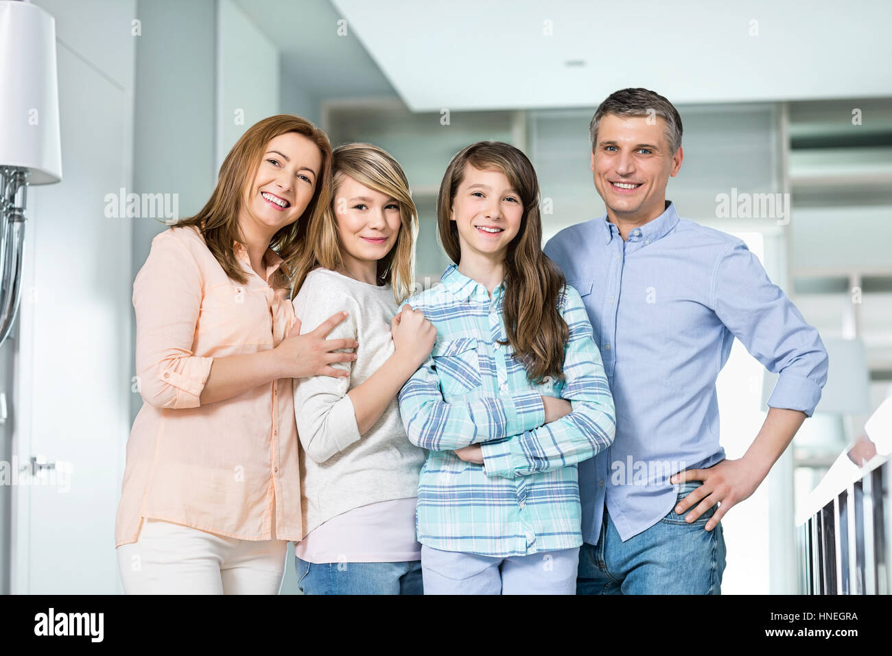 Ritratto di famiglia felice con bambini in piedi insieme a casa Foto Stock