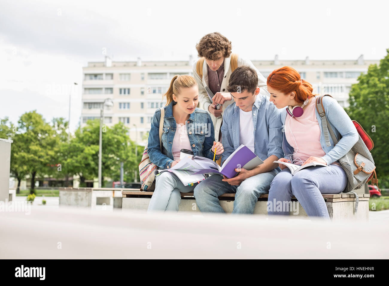 Gruppo di amici che studiano insieme nel campus universitario Foto Stock