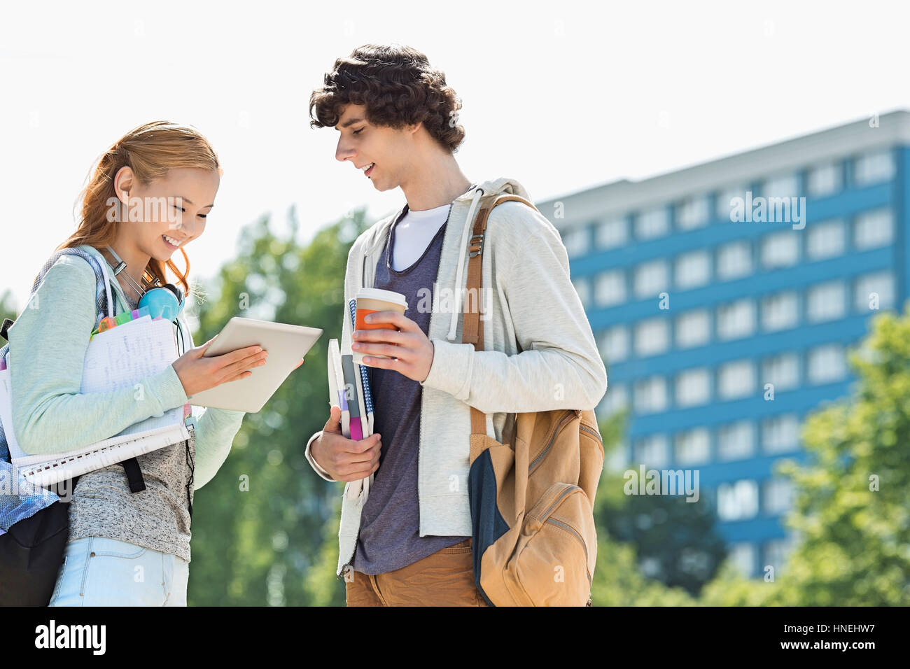 Studenti e studentesse con tavoletta digitale presso il college campus Foto Stock