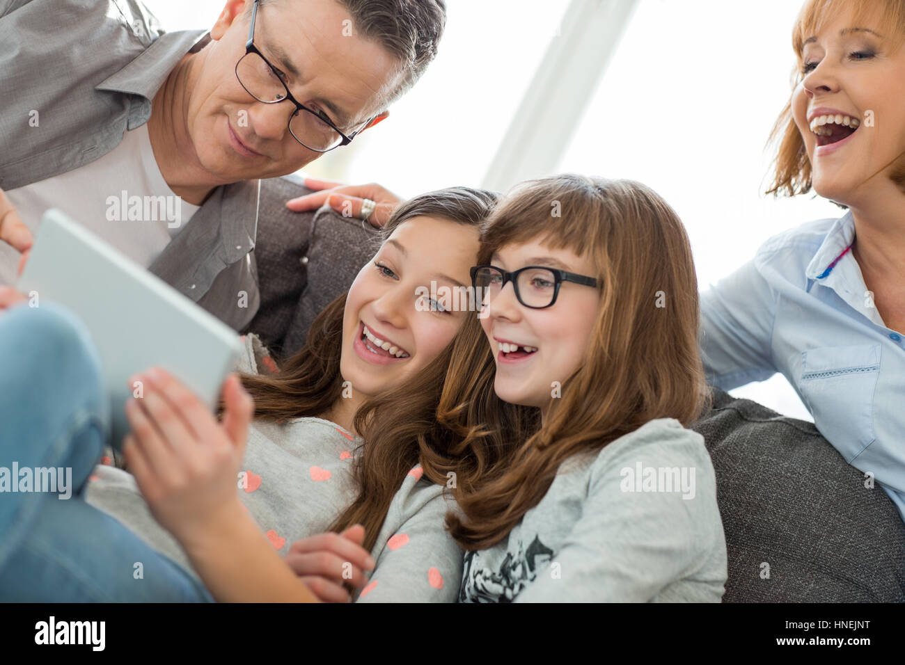 Famiglia allegra utilizzando tablet PC a casa Foto Stock
