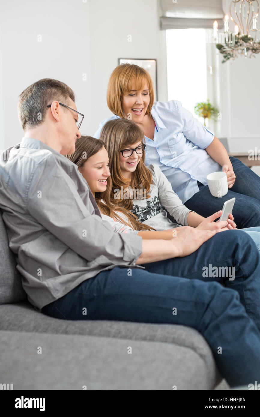 Famiglia allegra utilizzando tablet PC sul divano di casa Foto Stock