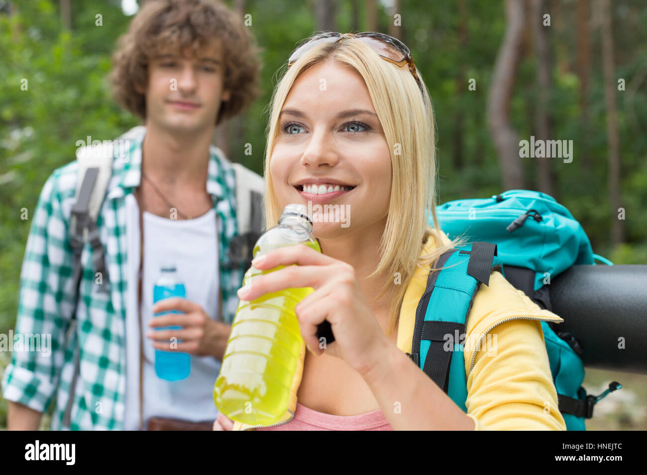 Escursionismo coppia con bevande energetiche in foresta Foto Stock