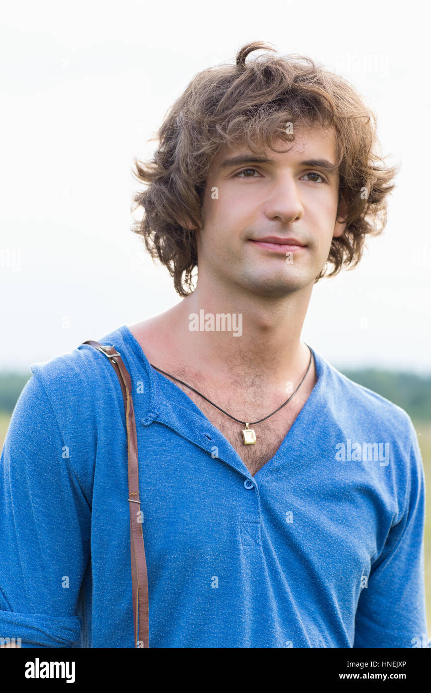 Giovane uomo che guarda lontano contro il cielo chiaro Foto Stock