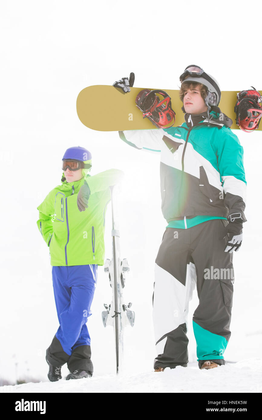 A lunghezza piena di giovani uomini con racchette da neve in neve Foto Stock