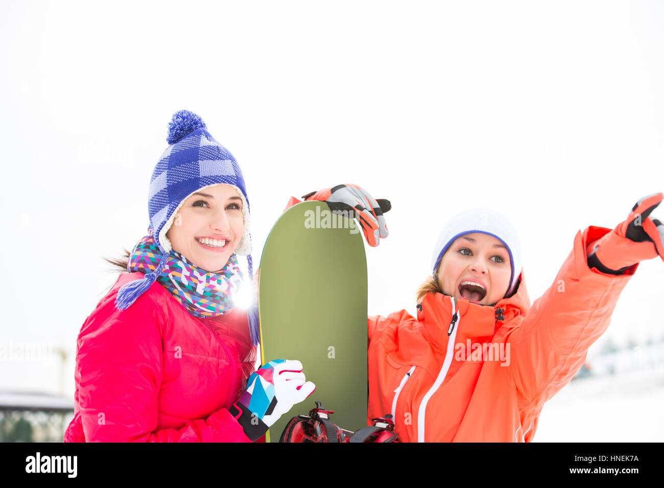 Emozionato amici di sesso femminile con lo snowboard all'aperto Foto Stock