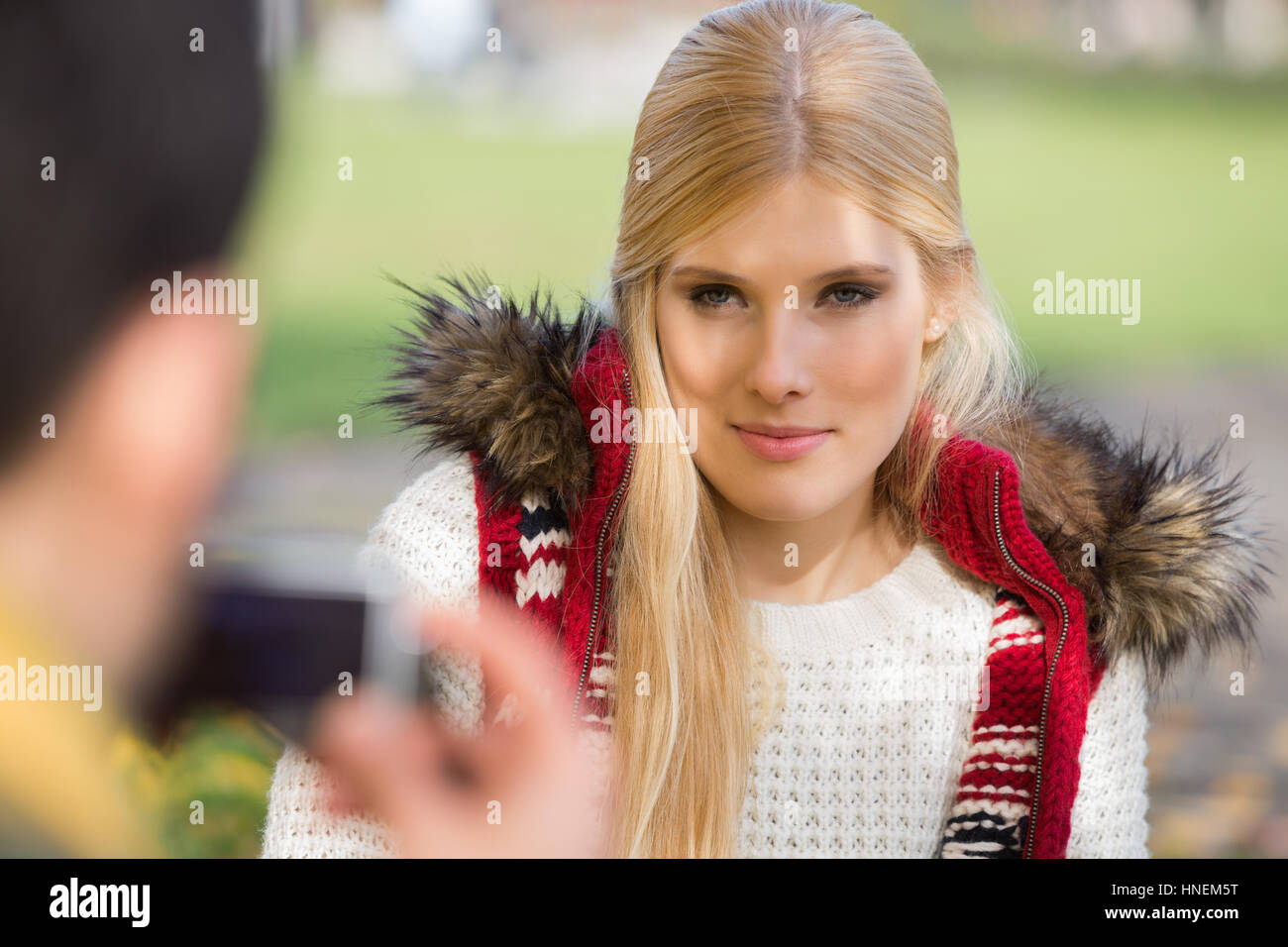 Bella giovane donna fotografata da uomo nel parco Foto Stock