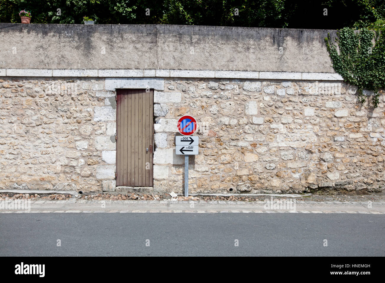 Nessun segno di parcheggio contro il muro di pietra Foto Stock