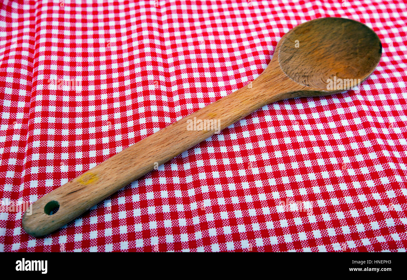 Cucchiaio di legno vicino fino a un rosso e tovaglie bianche Foto Stock