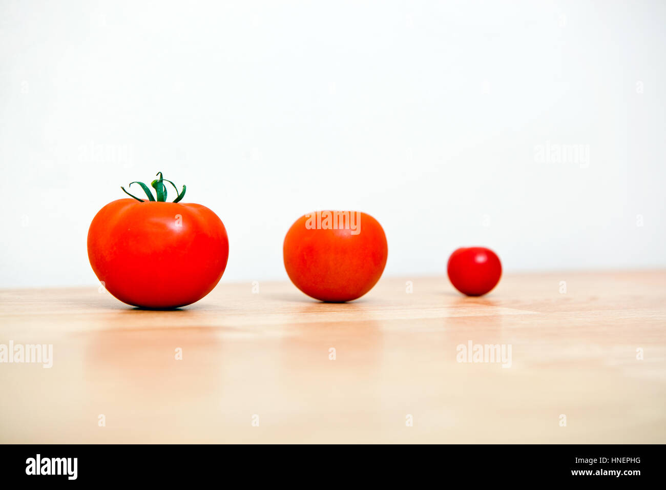 Studio shot di tre pomodori ciliegia in una riga Foto Stock