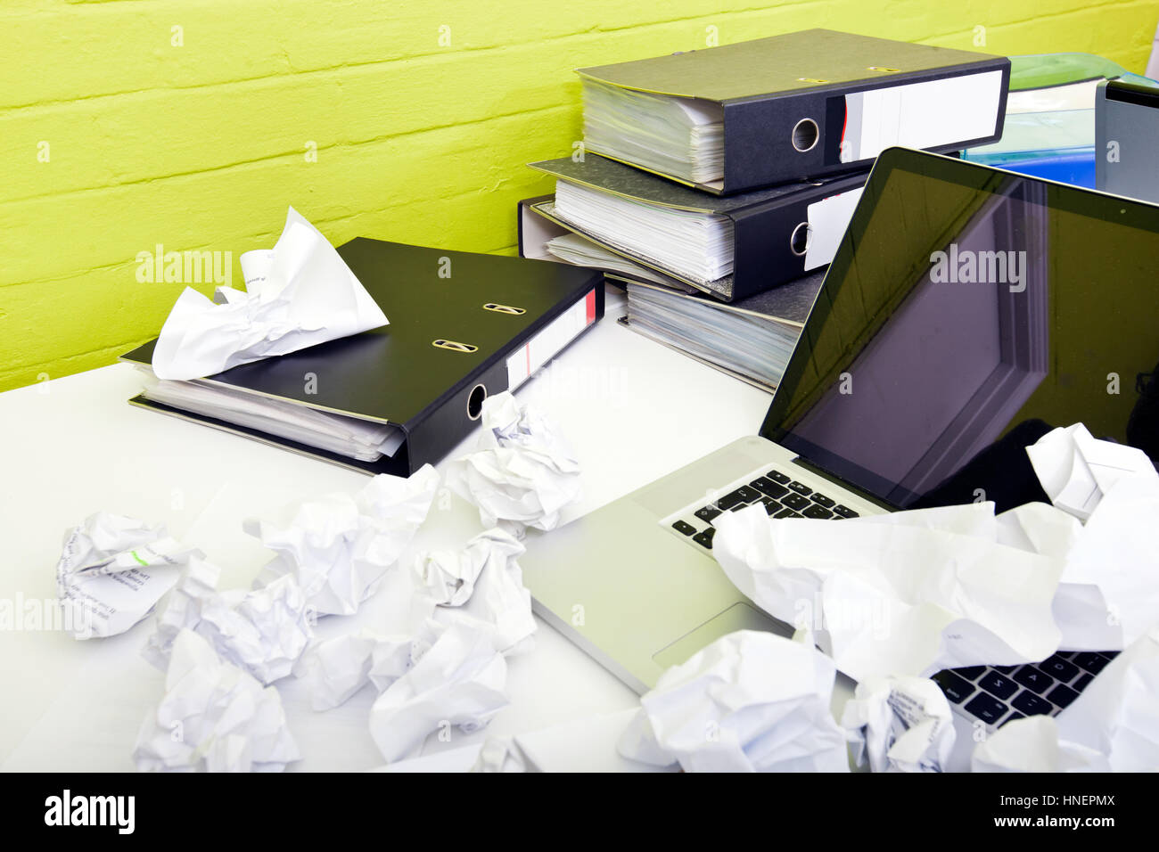 Vista ravvicinata di carta sgualcita su laptop sulla scrivania con sedia vuota e le cartelle Foto Stock