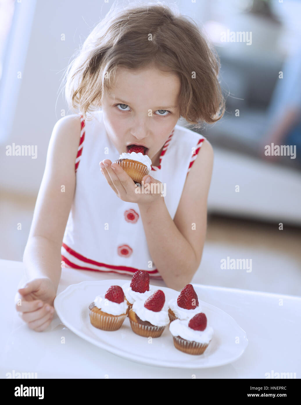 Ragazza giovane mangiare Cup cake Foto Stock
