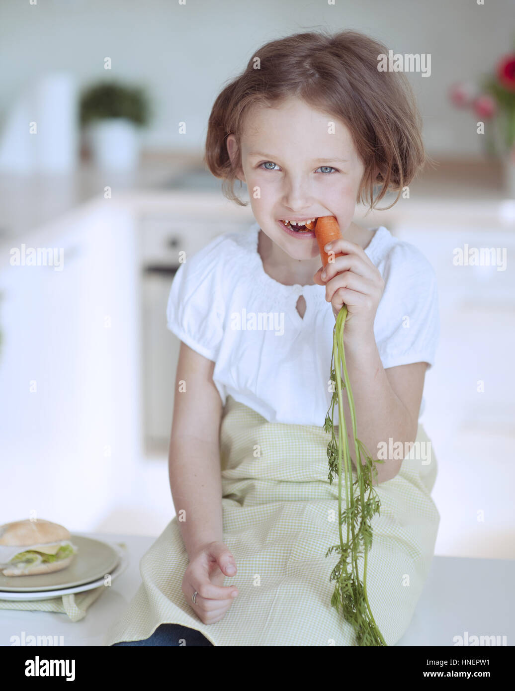 Ragazza giovane mangiando la carota Foto Stock