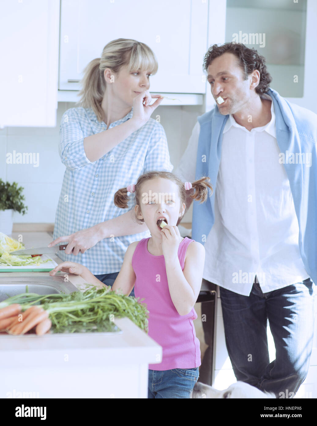 Famiglia facendo una sana insalata in cucina Foto Stock