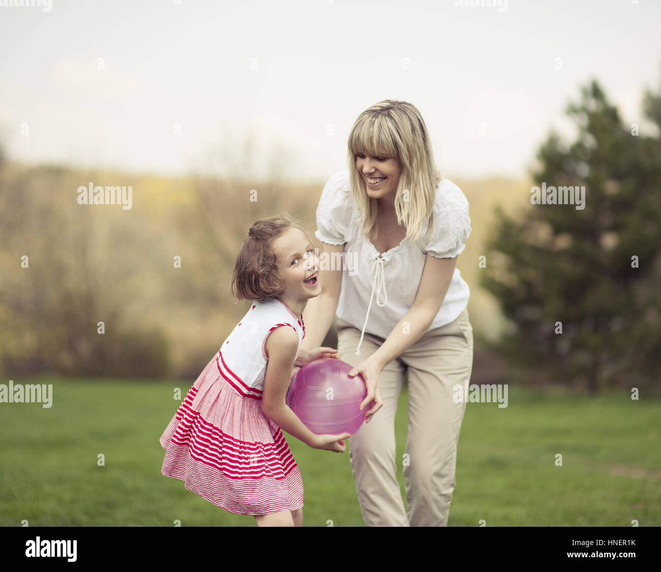 Madre e figlia gioca con la palla nel parco Foto Stock