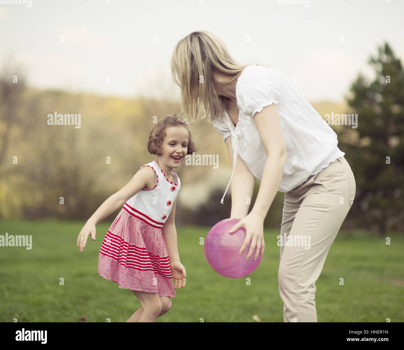 Madre e figlia gioca con la palla nel parco Foto Stock