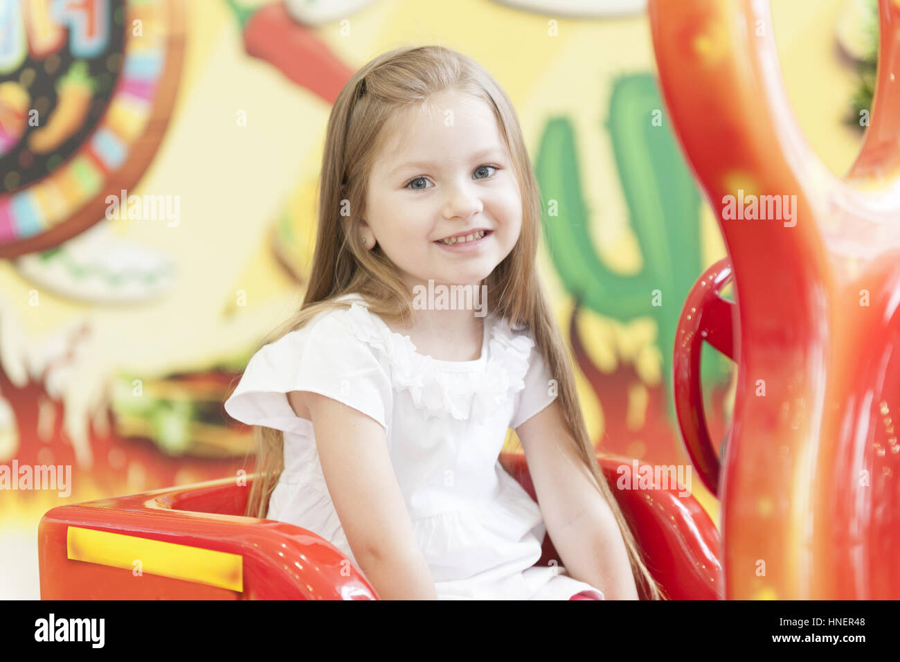 Giovane ragazza seduta su bambini in auto Foto Stock