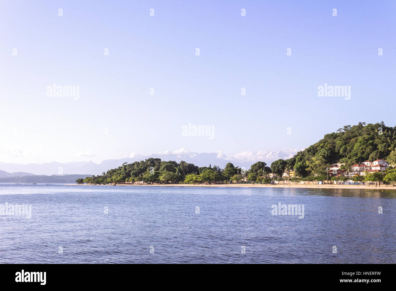 Il Brasile, Stato di Rio de Janeiro, Paqueta isola, vista della spiaggia durante il pomeriggio con le montagne sullo sfondo Foto Stock