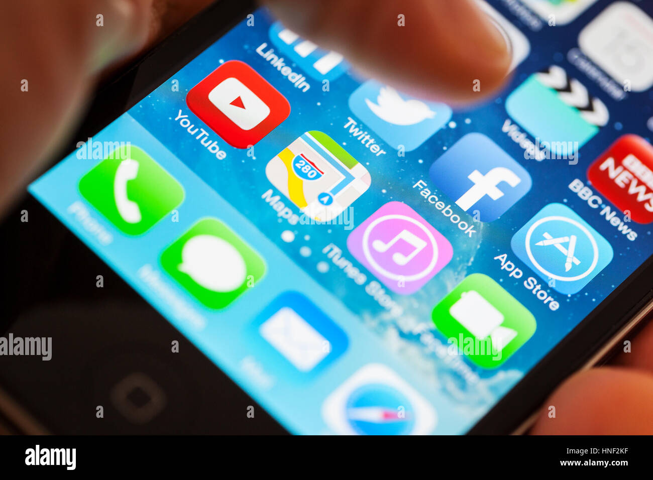 BATH, Regno Unito - 15 gennaio 2014: Close-up di un Apple iPhone 4s schermo con un uomo con il pollice in bilico sopra la app Facebook Messa a fuoco selettiva su Facebo Foto Stock