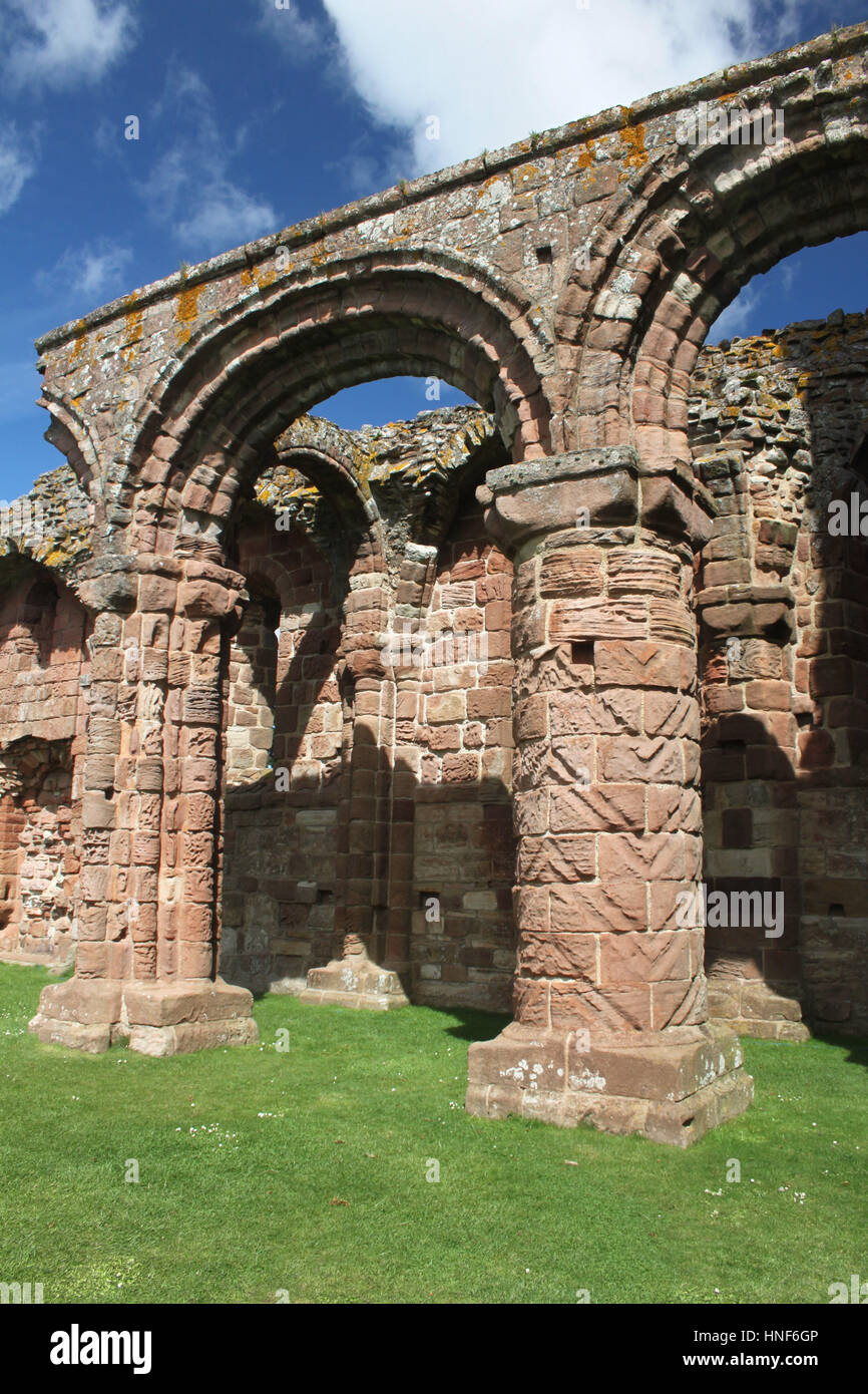 Archetti romanici e colonne in Lindisfarne Priory rovine. Le colonne incise sono simili alle iscrizioni in Durham Cathedral. Foto Stock