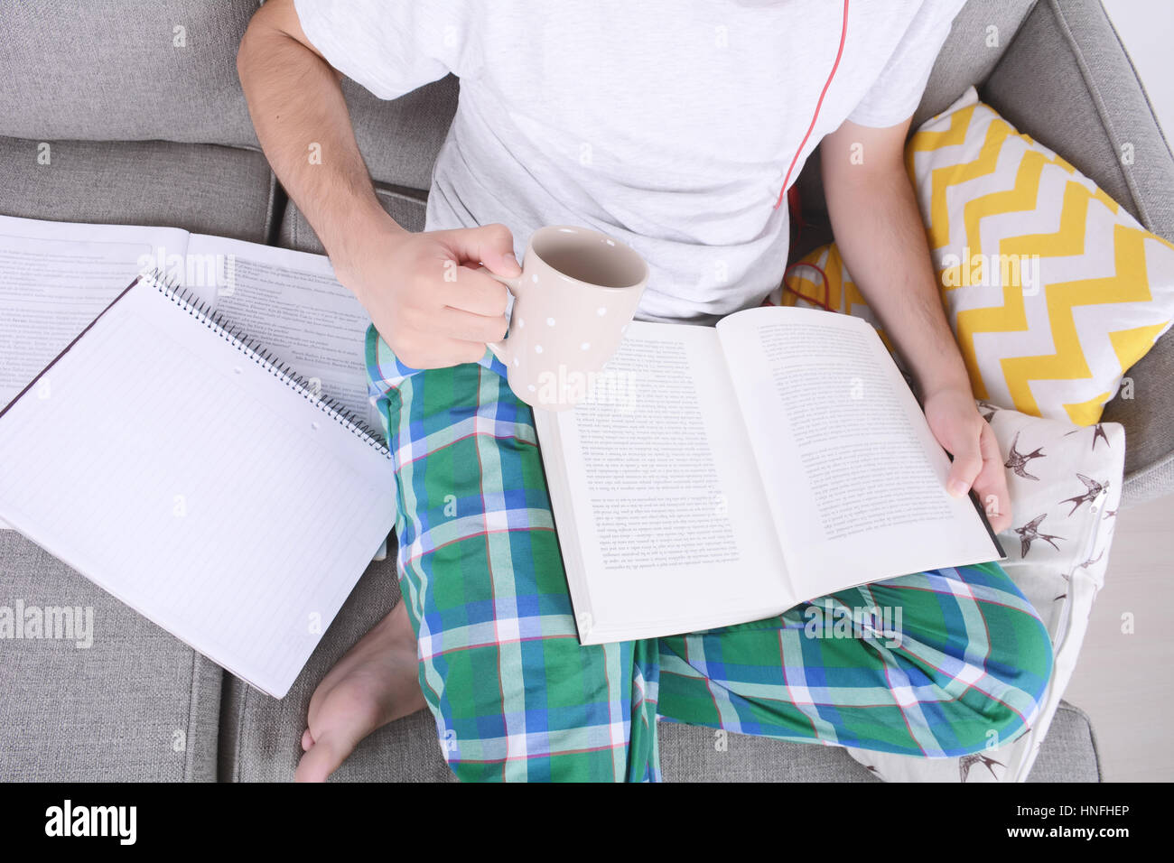 Attraente giovane studiando con la tazza di caffè. In ambienti chiusi. Foto Stock