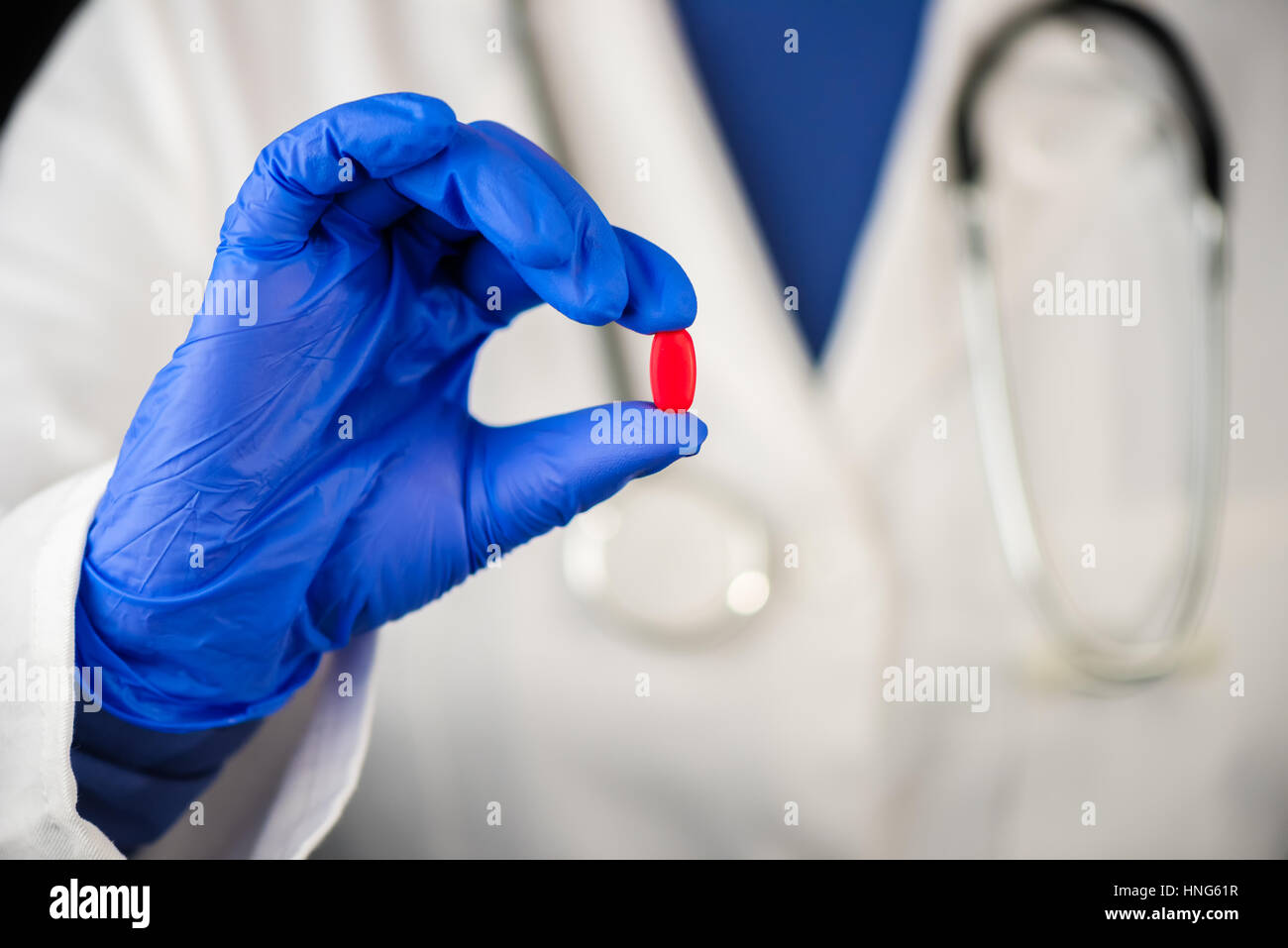 Medico donna offrendo red tablet pillola, irriconoscibile medico professionista azienda farmaco Foto Stock