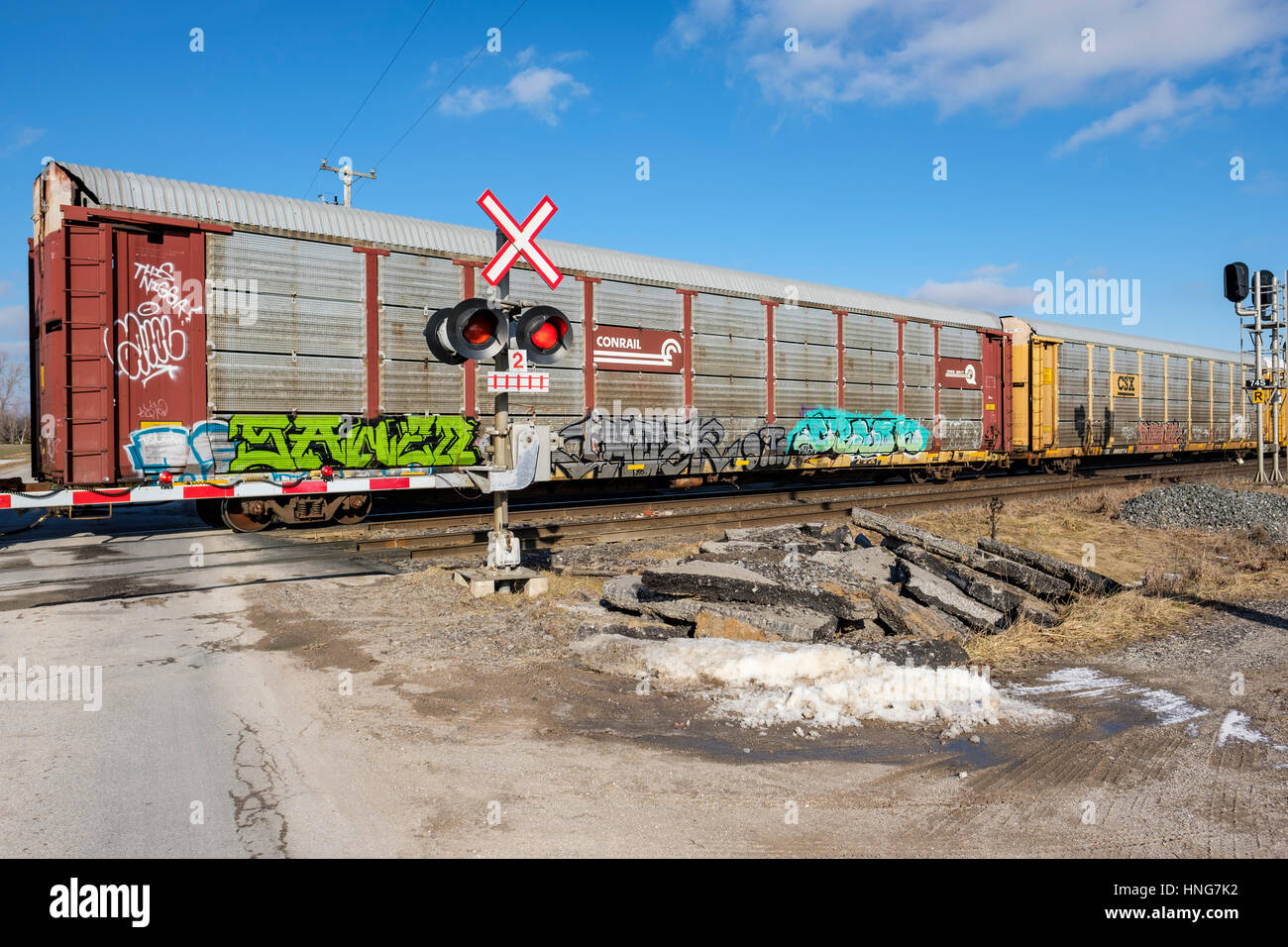 Nolo auto passando attraverso un passaggio a livello ferroviario durante il giorno nella zona sud ovest di Ontario, Canada. Foto Stock