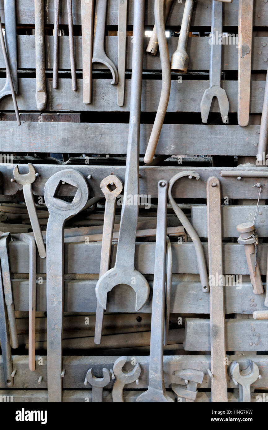 Close-up di grigio strumenti: File di chiavi e chiavi, appeso a un vecchio negozio di macchina, i colori neutri. Foto Stock