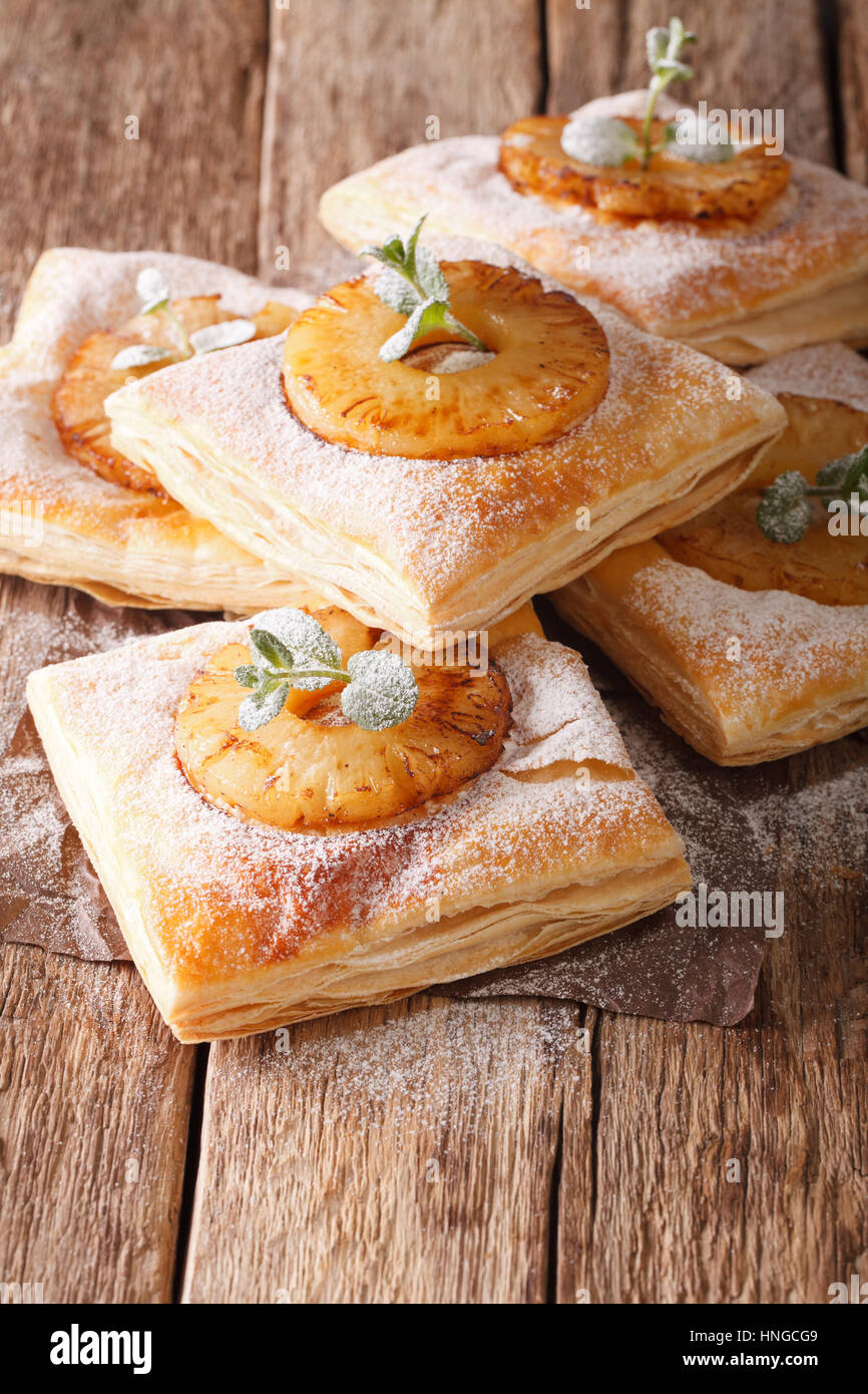 Dolce di pasta sfoglia torta con ananas e decorate con la menta e zucchero in polvere vicino sul piano verticale. Foto Stock