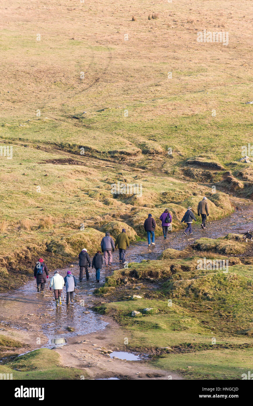Un gruppo di escursionisti su terreni accidentati Tor, designato come una zona di straordinaria bellezza naturale a Bodmin Moor in Cornovaglia. Foto Stock