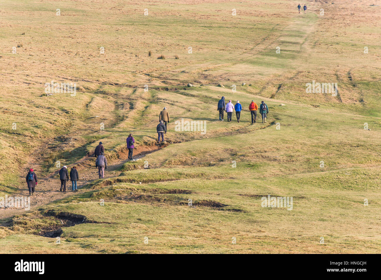 Un gruppo di escursionisti su terreni accidentati Tor, designato come una zona di straordinaria bellezza naturale a Bodmin Moor in Cornovaglia. Foto Stock
