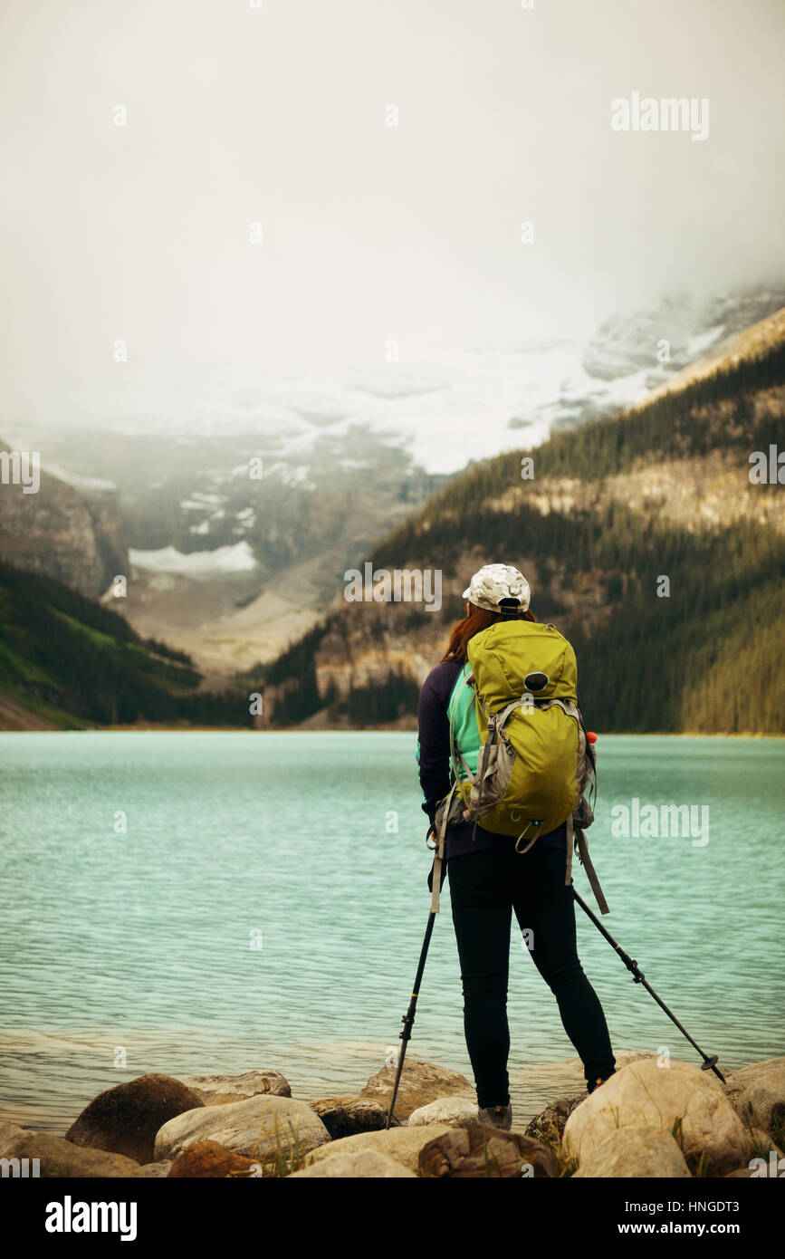 Una femmina di escursionista presso il Lago Louise in Banff National Park con le montagne e le foreste in Canada. Foto Stock