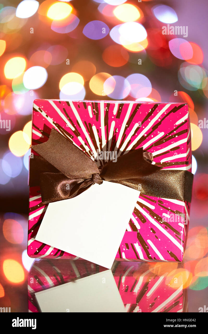 Square presente scatola con nastro sul Natale sfocato sfondo luminoso Foto Stock