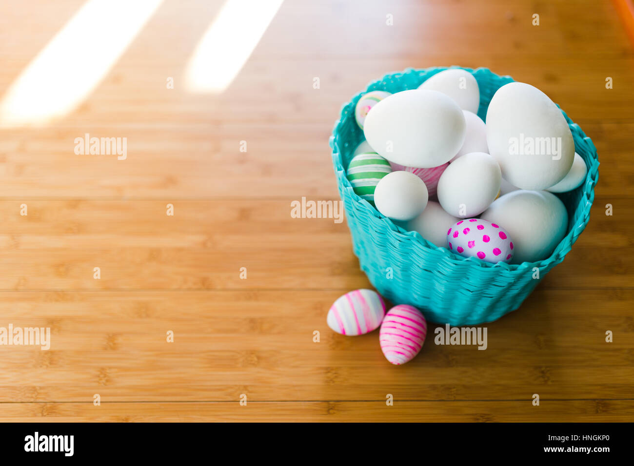 Cesto di pasqua con uova su un pavimento di legno Foto Stock