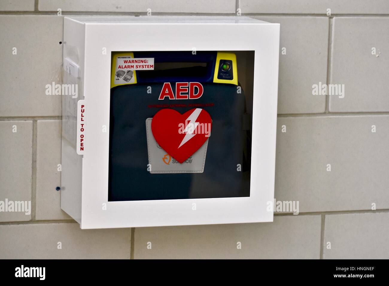 Un defibrillatore semiautomatico esterno (AED) sulla parete di una scuola Foto Stock