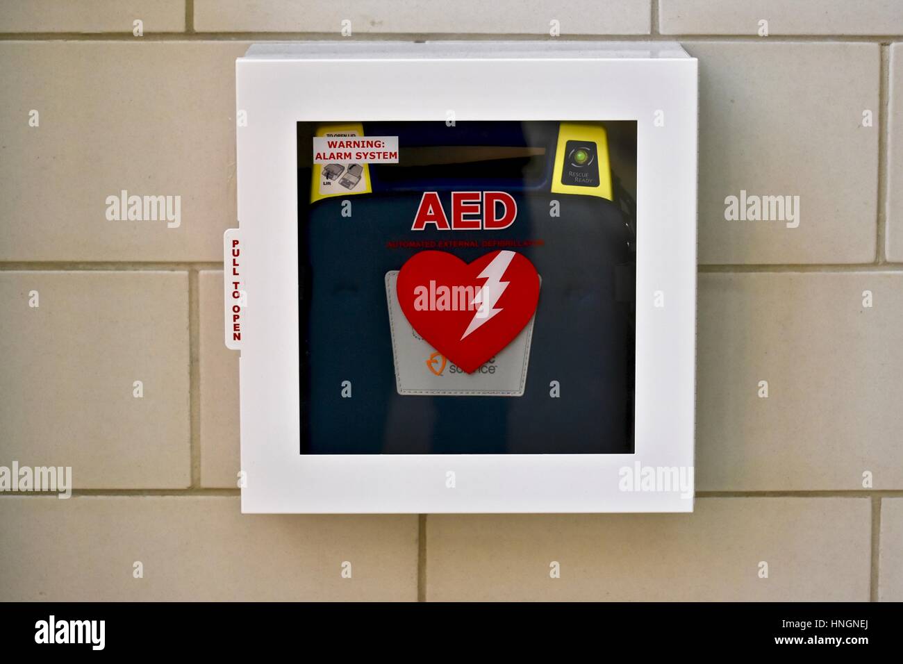 Un defibrillatore semiautomatico esterno (AED) sulla parete di una scuola Foto Stock