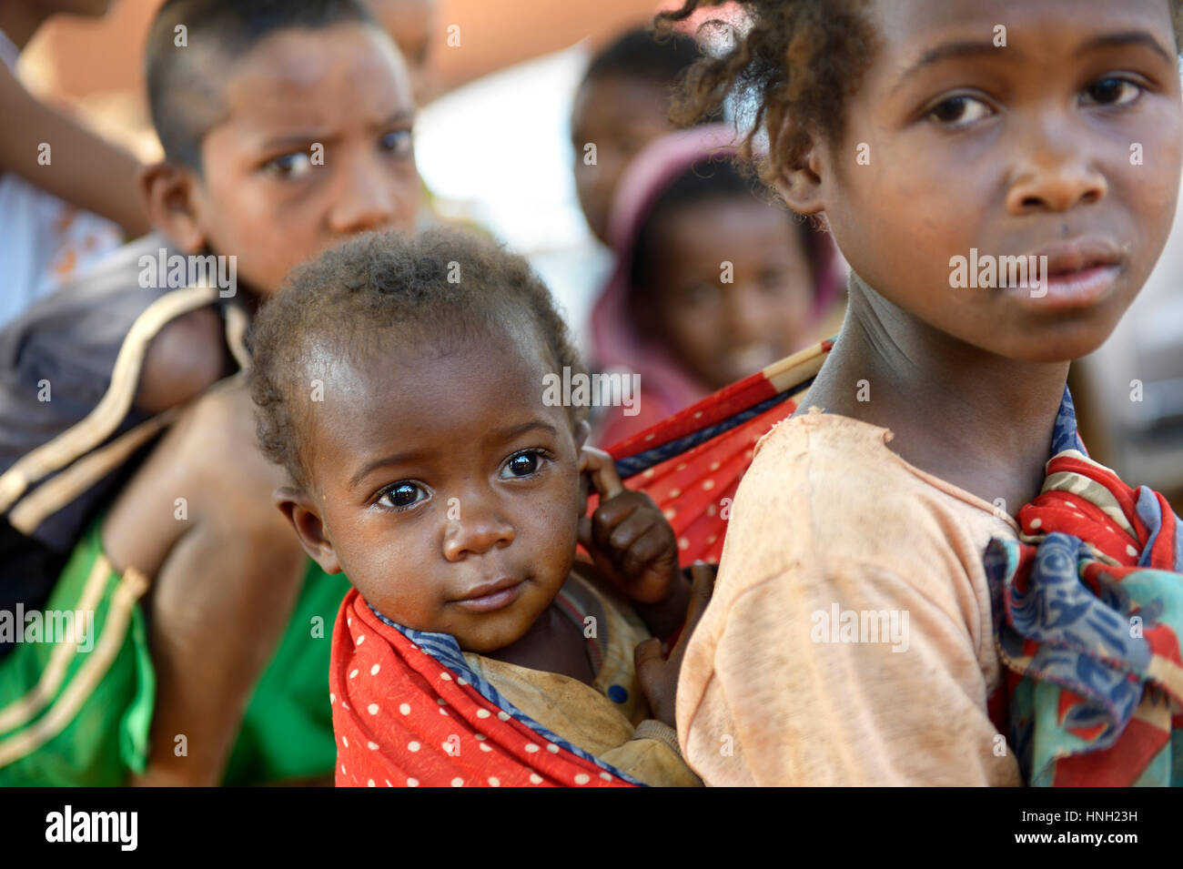 Ragazza sorella portante sulla sua schiena, Analakely village, Tanambao comune, Madagascar Foto Stock
