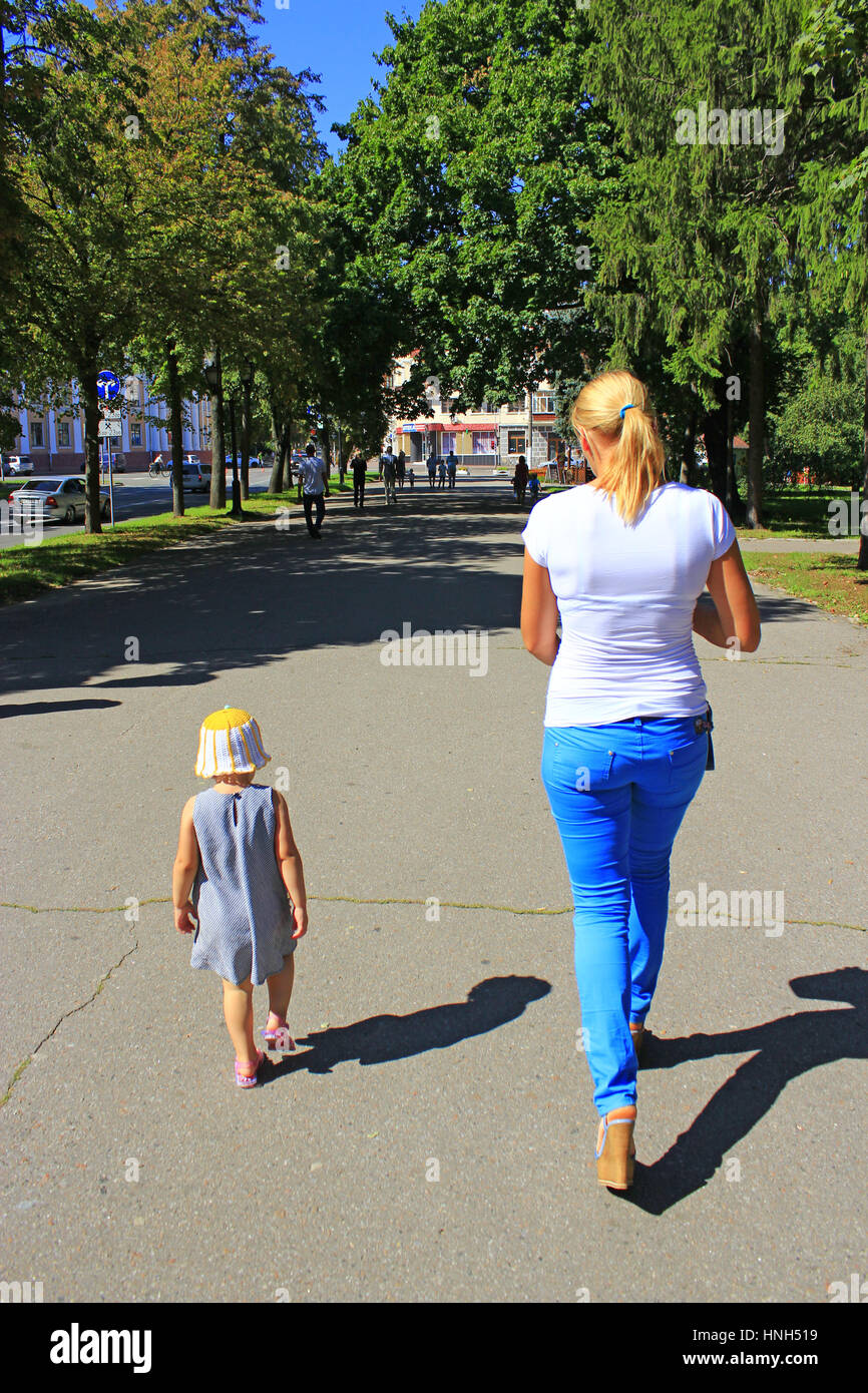 Moda Donna a piedi con la sua piccola figlia nel parco della città di Chernihiv Foto Stock