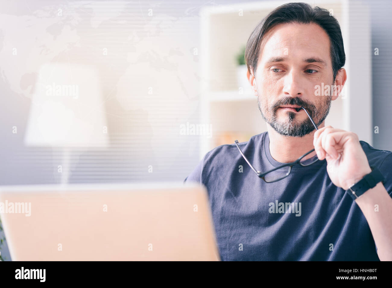 Riflessivo uomo seduto al tavolo Foto Stock