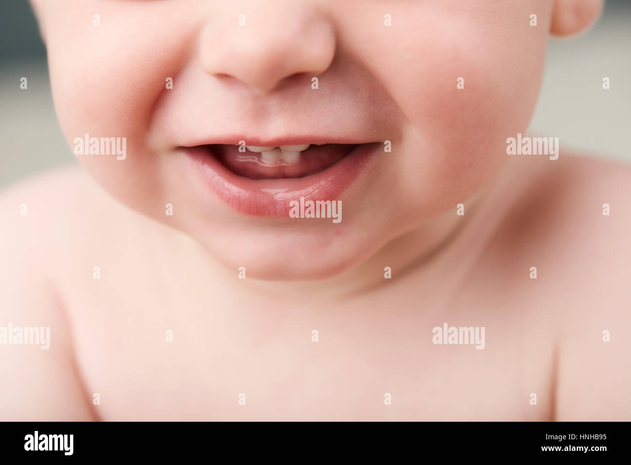 Raccolto di tenuta della bocca del bambino che mostra i suoi primi denti Foto Stock