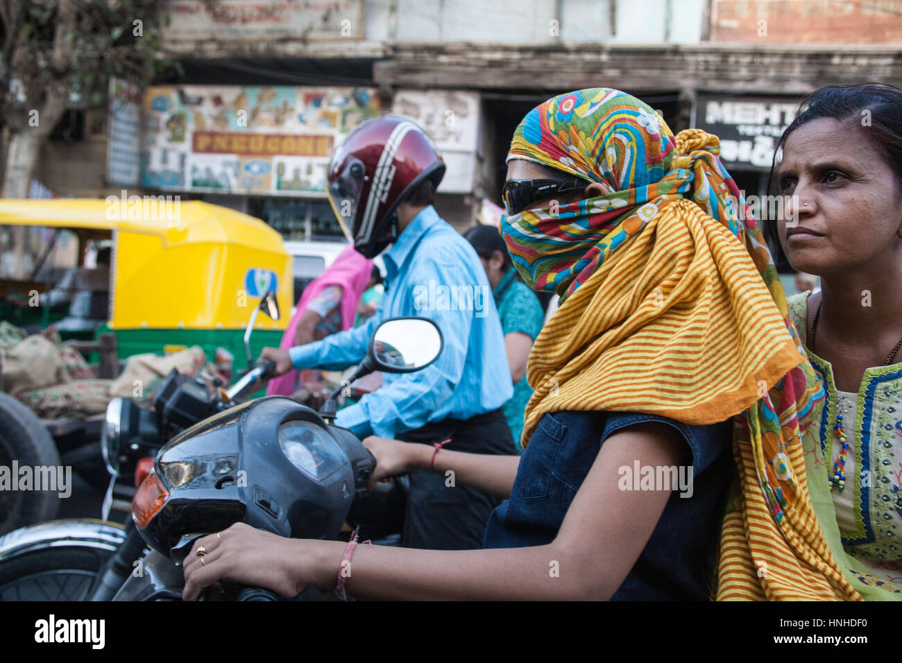 Traffico,moto,scooter,l'inquinamento,pillion,passeggeri,indossando,faccia,maschere,coperto,fumi,l'inquinamento,Ahmedabad,Gujurat,l'India,Asia,asiatica, Foto Stock