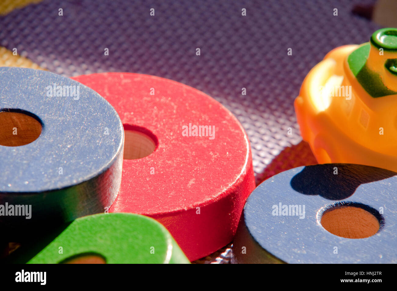 Tappeto di bambini con giocattoli, una barca di gomma e dischi di legno Foto Stock