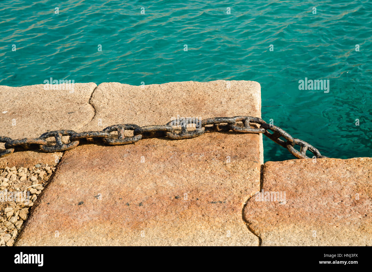 Rusty catena su un dock, con il mare mediterraneo come sfondo Foto Stock