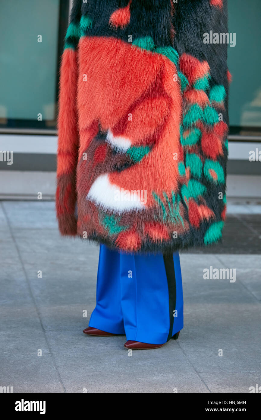 Donna con orange pelliccia e pantaloni blu prima di Emporio Armani fashion show, la Settimana della Moda Milanese street style on gennaio Foto Stock