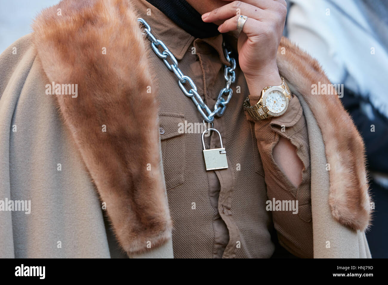 Uomo con golden indovinare guarda e marrone collare di pelliccia prima di Salvatore Ferragamo fashion show, la Settimana della Moda Milanese street style nel gennaio 2017. Foto Stock