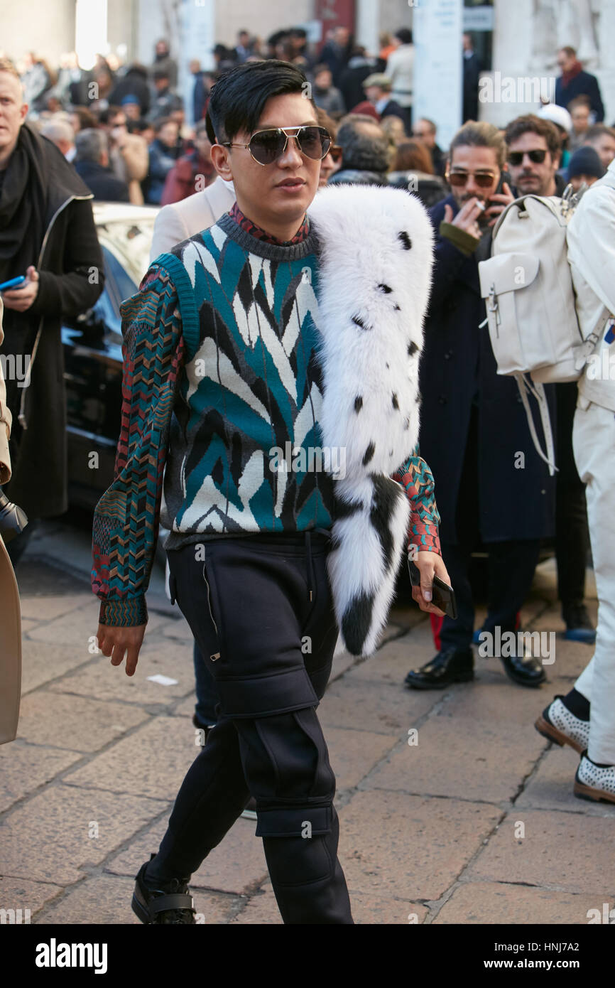 Bryan Boy con pelliccia bianca sciarpa e disegno geometrico maglione prima di Salvatore Ferragamo fashion show, la Settimana della Moda Milanese street style. Foto Stock