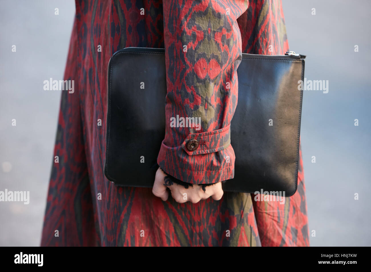 Uomo con red decorate trench coat e nero borsa in pelle prima di Etro fashion show, la Settimana della Moda Milanese street style on gennaio 16, 2017. Foto Stock