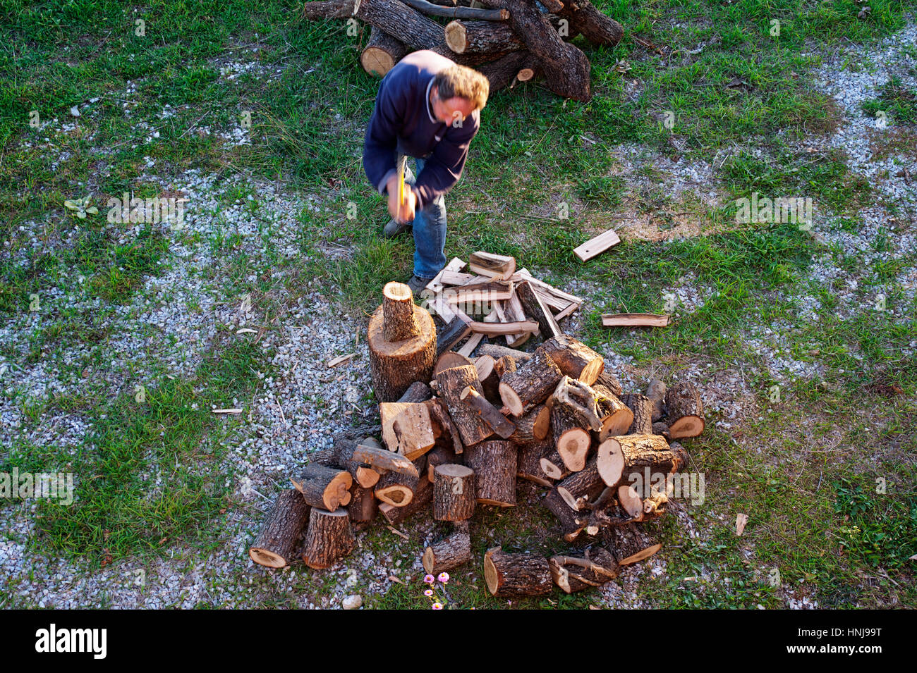 Un uomo di mezza età trinciatura di legna da ardere Foto Stock