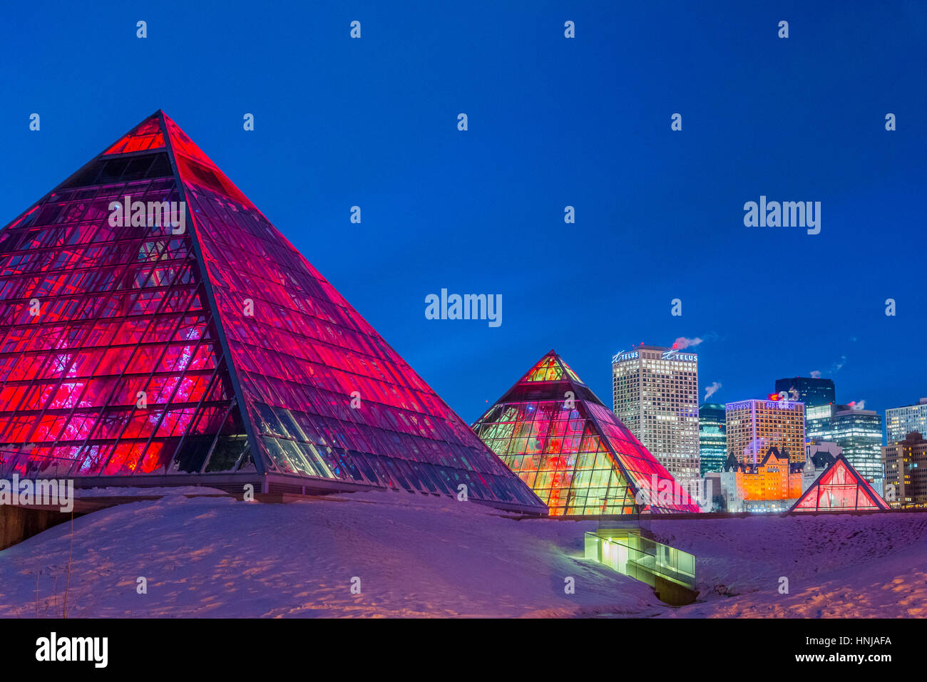 Lo skyline di Edmonton e illuminato Muttart Conservatory piramidi, un giardino botanico in Edmonton, Alberta, Canada Foto Stock