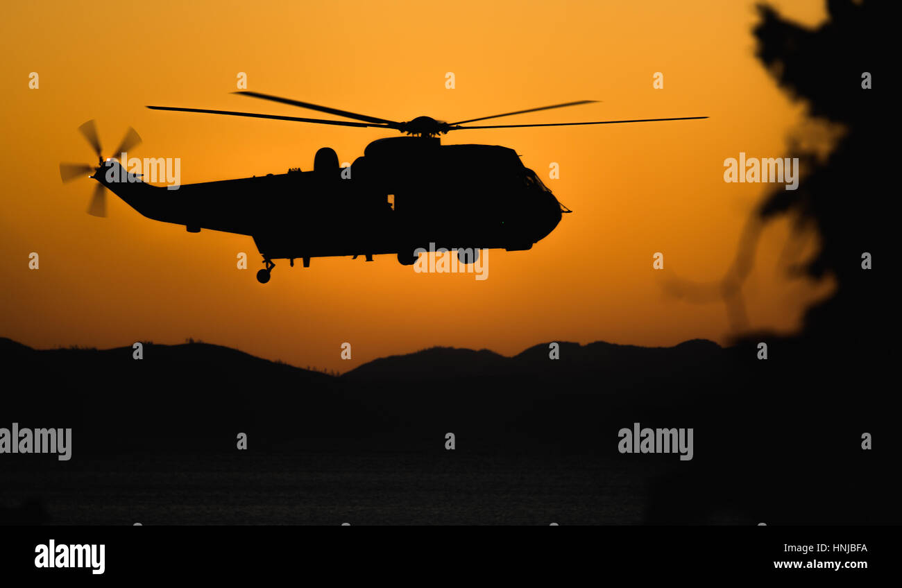 Navy Salvataggio in elicottero volando sopra le montagne Foto Stock