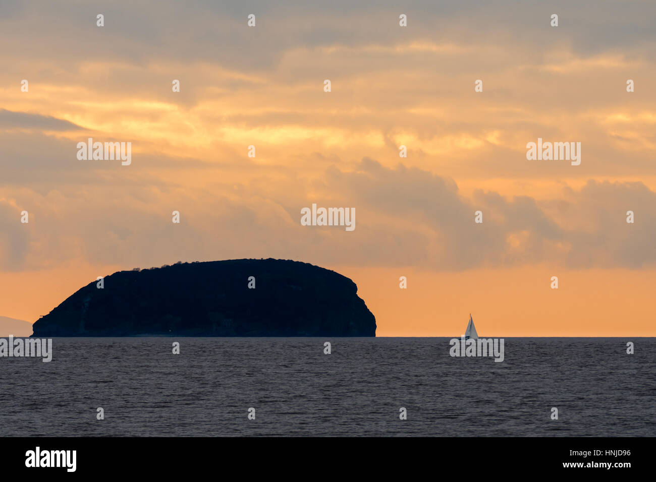 Tramonto dietro Steep Holm isola nel Canale di Bristol, con yacht spettacolare Cielo e nubi visto da Weston-super-Mare nel Somerset, Regno Unito Foto Stock